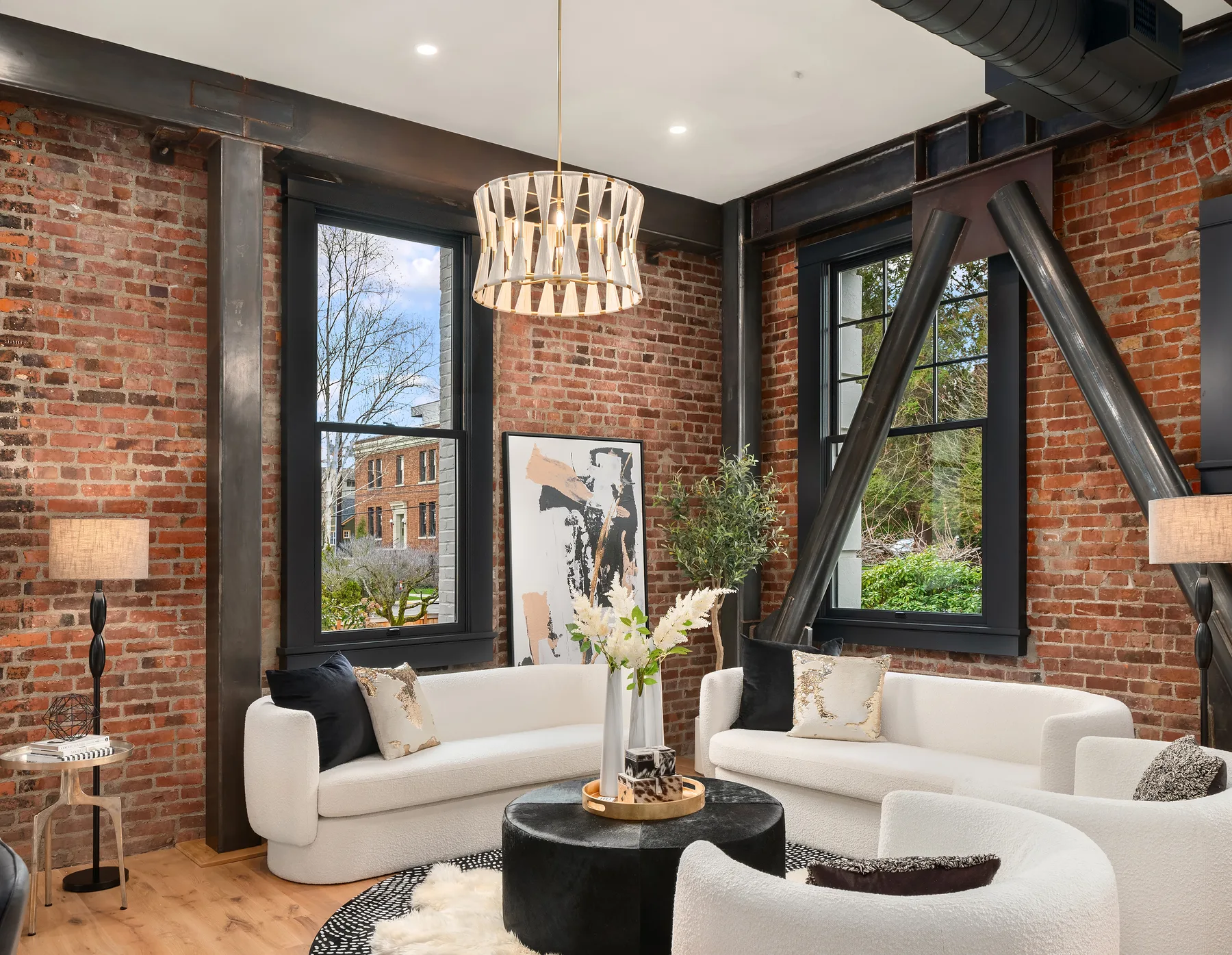 Sitting room with tall windows, exposed brick, and diagonal steel structural bracing