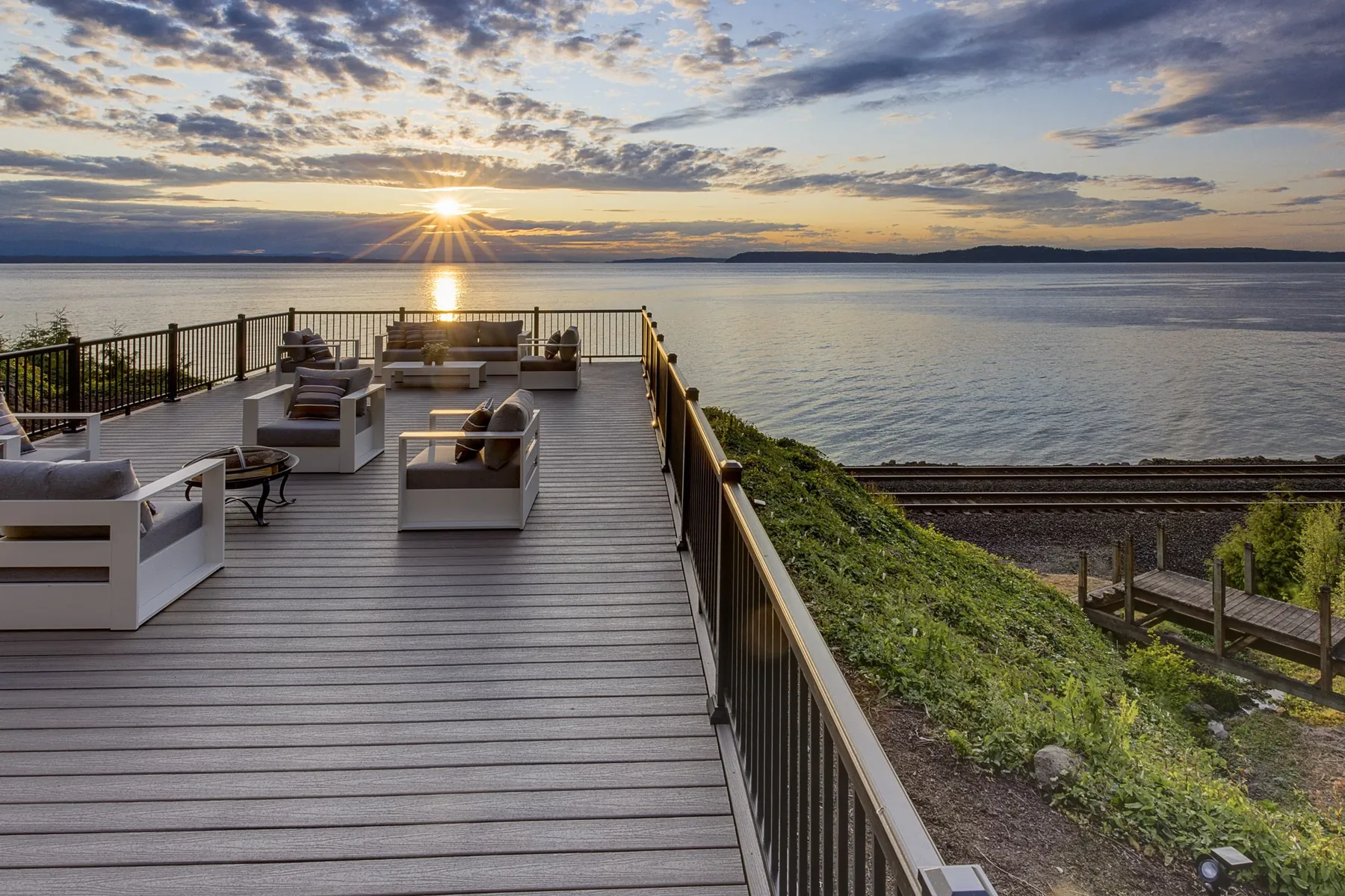 Waterfront home staging by RD Interiors with a styled outdoor deck and uninterrupted sunset views across the Sound
