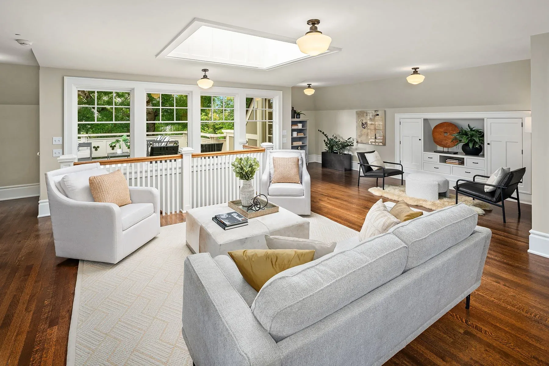 Capitol Hill home staging featuring an upper-level sitting room with a skylight, white sofa, and a refined gallery-style layout
