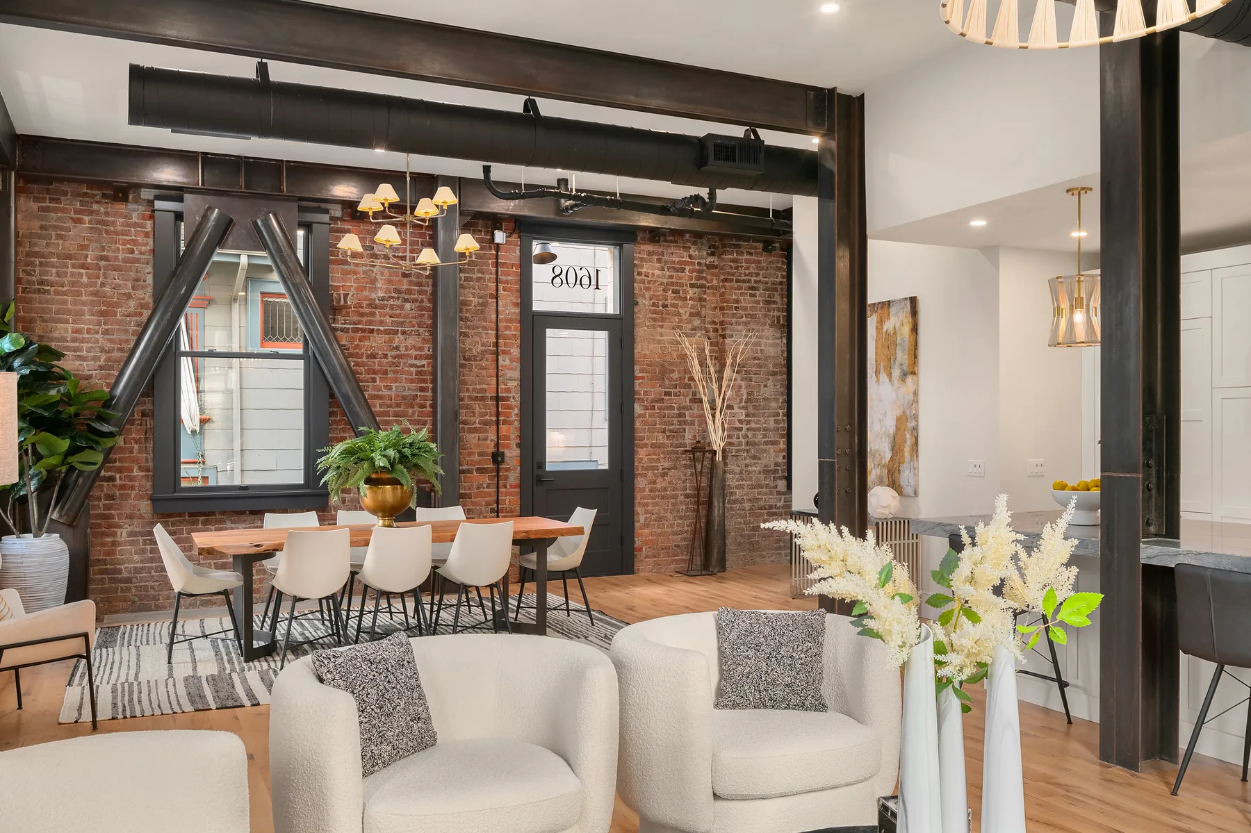 Dining room with a sliding barn door, brick accent wall, and curated greenery