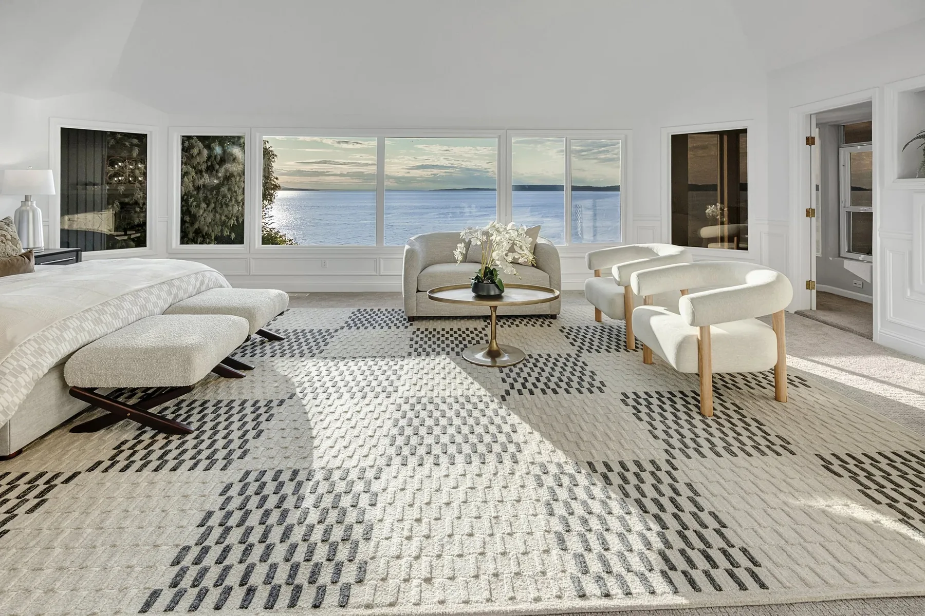 Seattle luxury home staging featuring a sitting room with twin armchairs, a chaise, and a geometric rug overlooking the Sound
