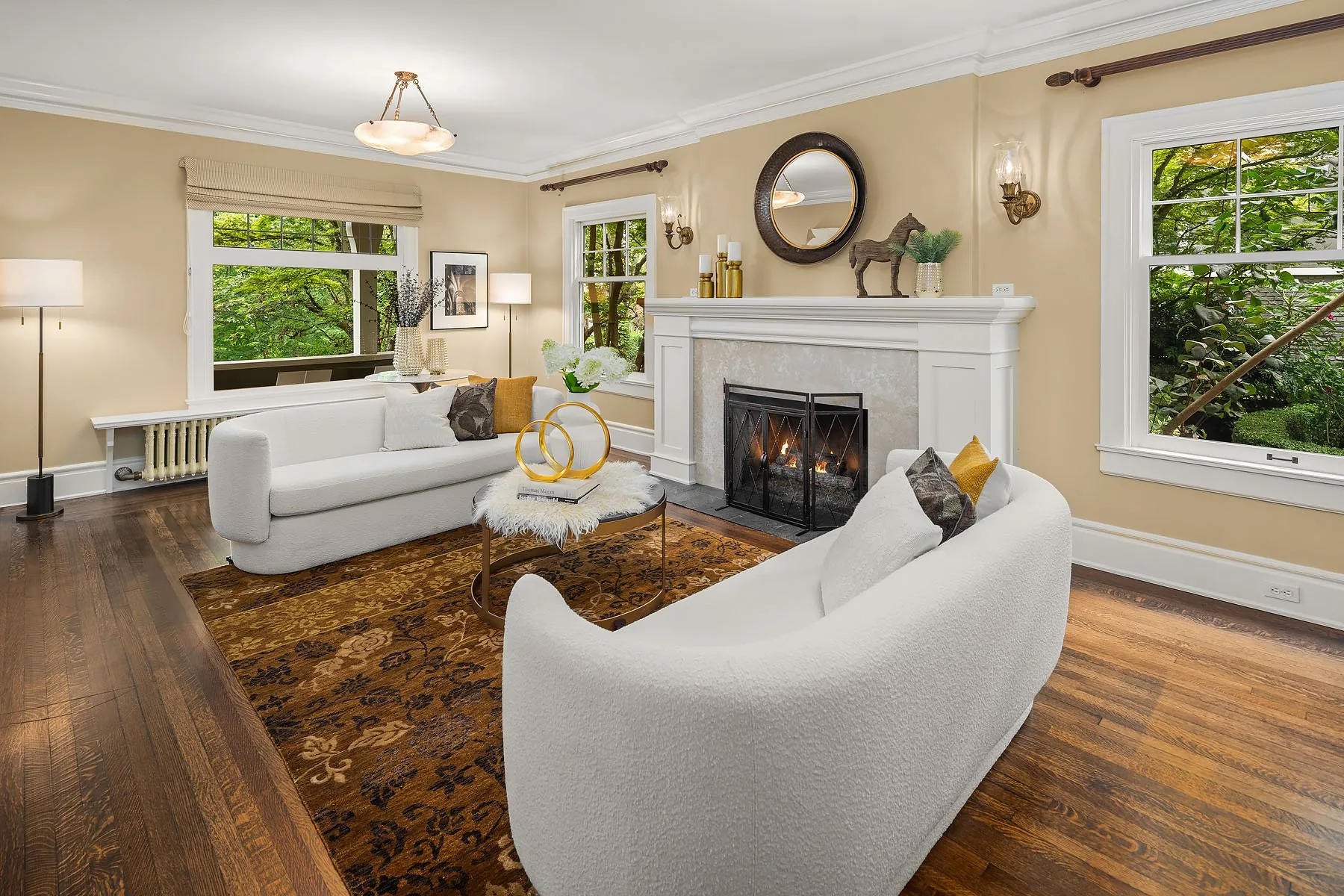 Seattle luxury home staging featuring a classic living room with a wood-mantel fireplace, layered seating, and a patterned area rug
