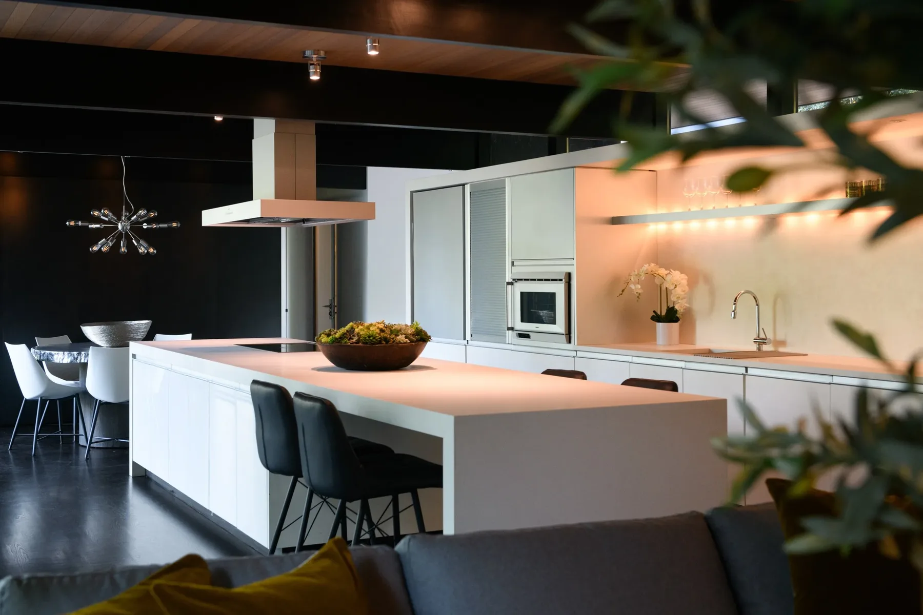 Seattle luxury home staging featuring a kitchen island with bar seating, a sculptural pendant, and a dark range hood