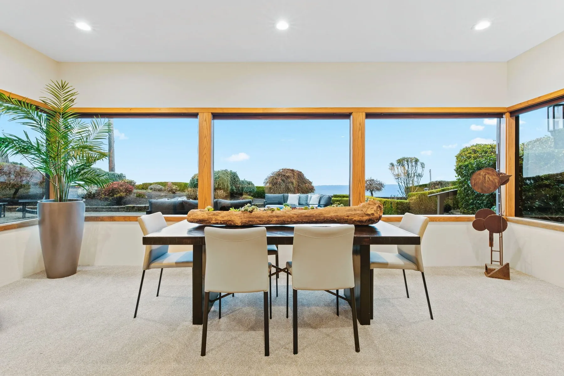 Seattle luxury home staging with a dining area framed by walls of glass and uninterrupted water views