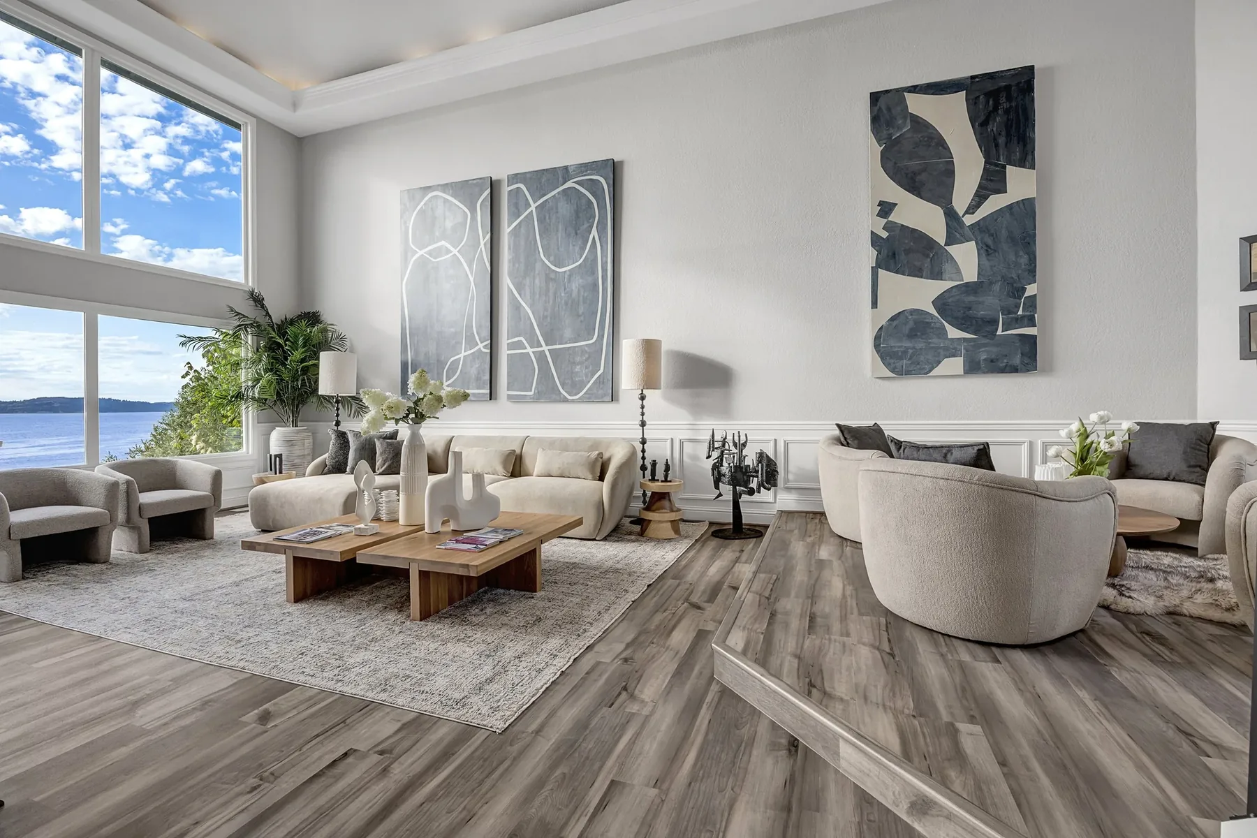 Seattle home staging featuring a light-filled living room with floor-to-ceiling windows, a curved bouclé chair, and abstract art