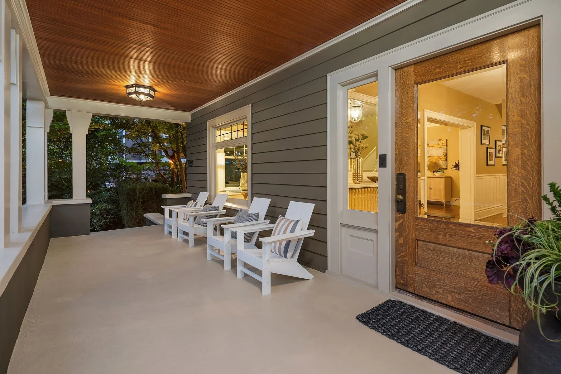 Seattle luxury home staging with a craftsman covered entry porch, wood front door, and curated outdoor seating