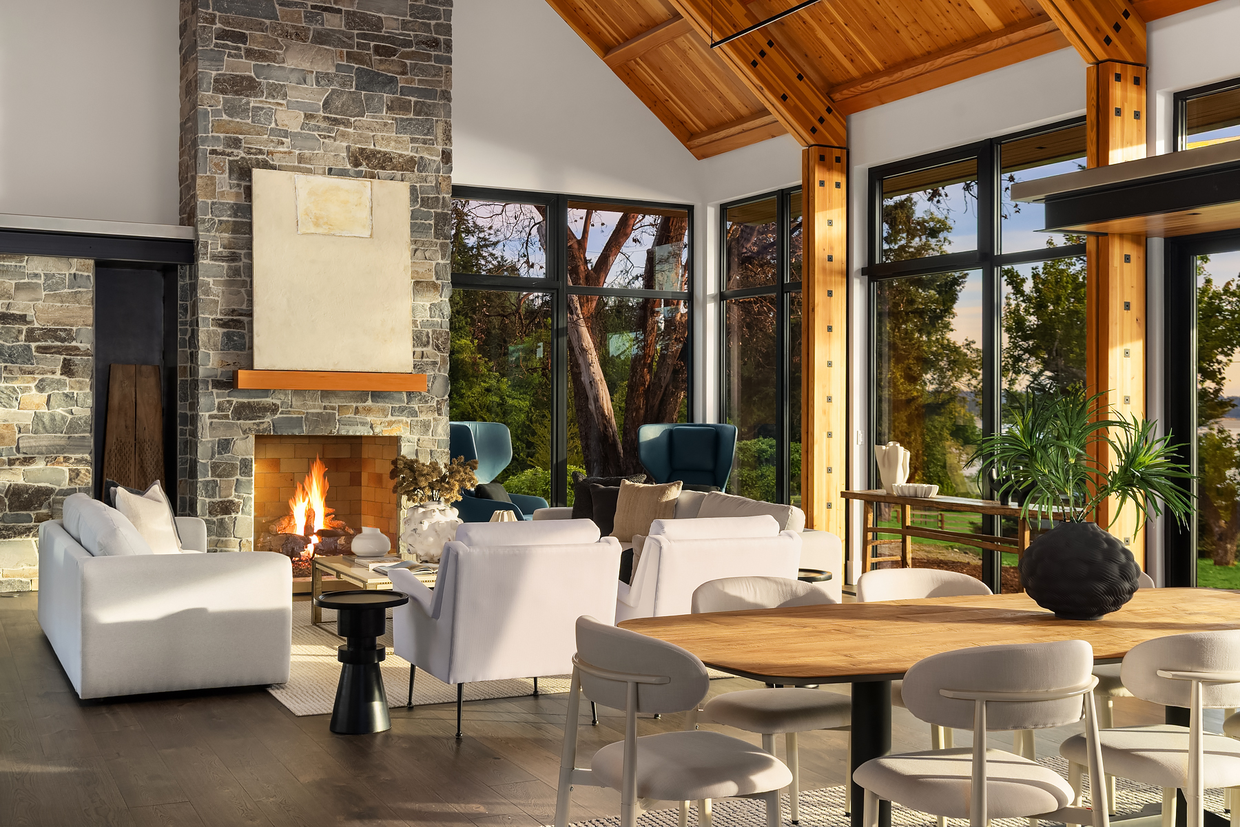 Open-concept great room on Bainbridge Island with vaulted cedar ceilings, a dining area, and staged seating oriented toward the water