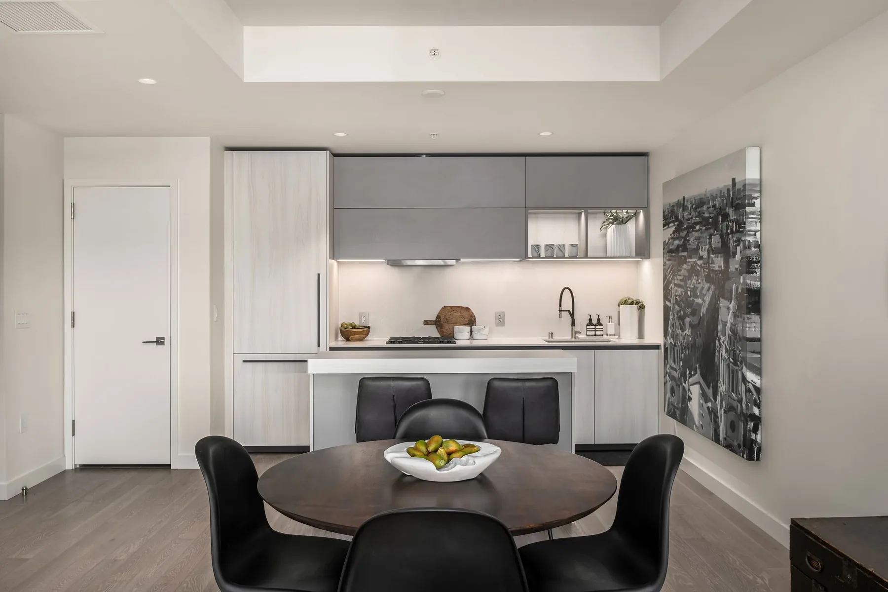 Downtown home staging with a sleek dining area beside a minimalist kitchen and a framed black-and-white city map