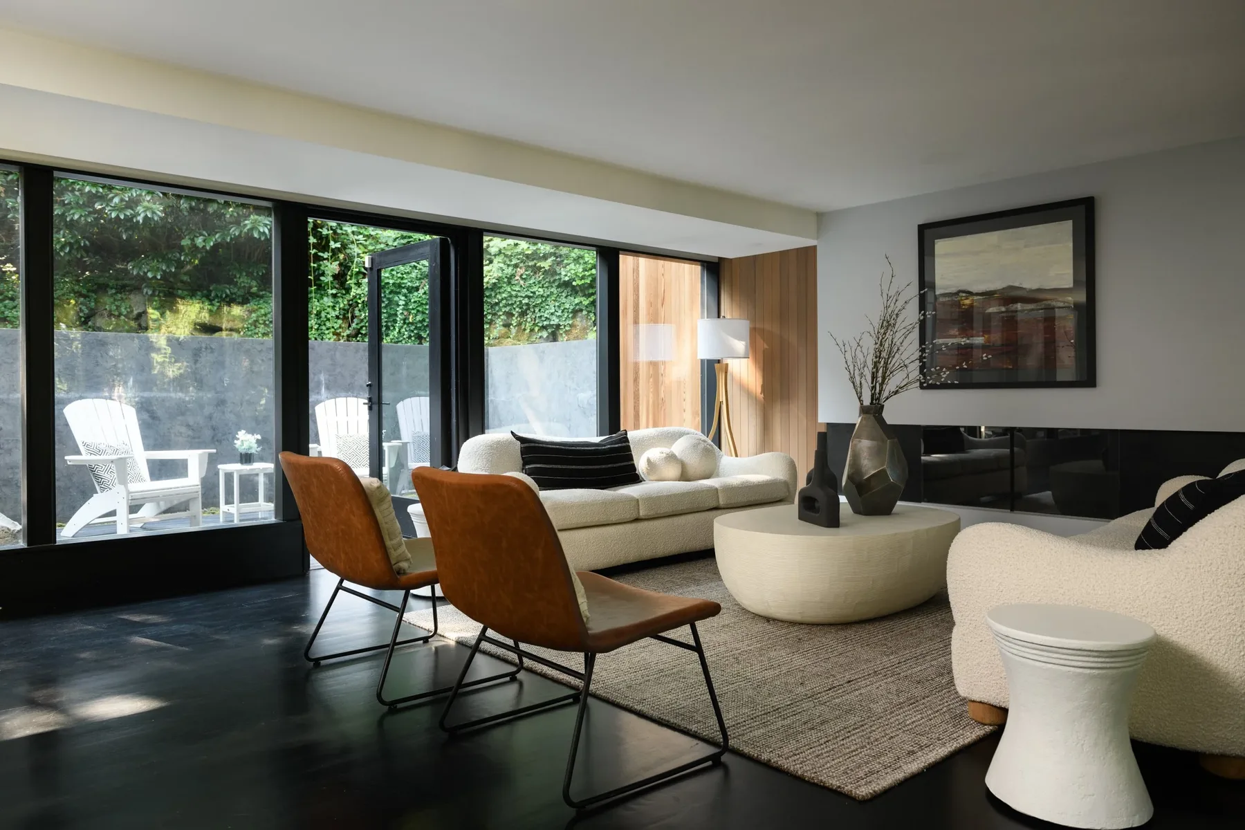 Seattle luxury home staging with a light-filled living room, floor-to-ceiling windows, leather accent chairs, and a curved sofa